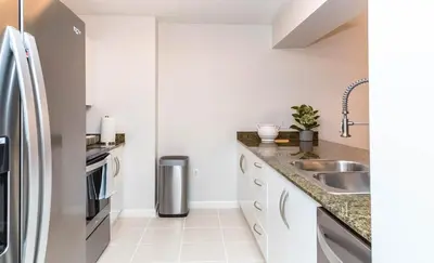 a kitchen with white cabinets and a stainless steel refrigerator at Top Stay Miami Blue Brickell in Miami