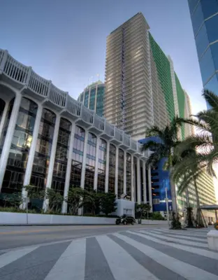 a building with palm trees in front of tall buildings at Top Stay Miami Blue Brickell in Miami