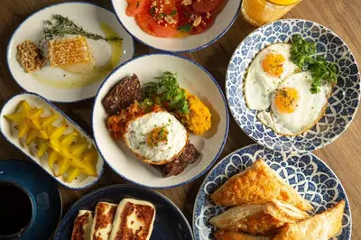 a table topped with plates of eggs and bread at Hotel Indigo Miami Brickell by IHG in Miami