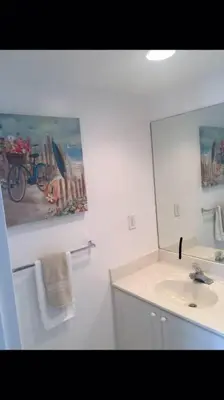 a white bathroom with a sink and a mirror at Tides Beachfront Resort - 2 Bedroom Direct Oceanview Condo in Hollywood