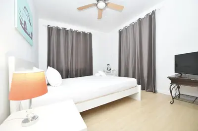 a bedroom with a bed and a flat screen tv at Sobe Apartments in Miami Beach