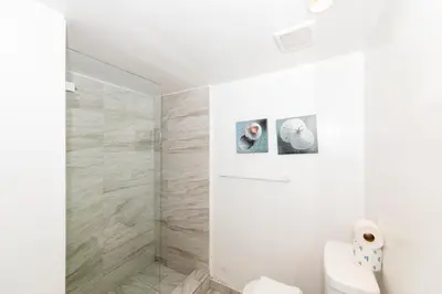 a bathroom with a toilet and two pictures on the wall at Sobe Apartments in Miami Beach