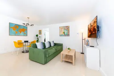 a living room with a green couch and a table at Sofi Beach Apartments in Miami Beach