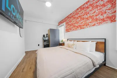 a bedroom with a large white bed and a wall at Greenview Hotel By Lowkl in Miami Beach
