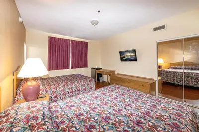a hotel room with two beds and a lamp at Ocean Beach Suites in Miami Beach