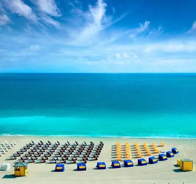 a beach with a bunch of lounge chairs and the ocean at Ocean Beach Suites in Miami Beach