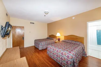 a hotel room with two beds and a tv at Ocean Beach Suites in Miami Beach