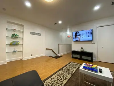 a living room with a flat screen tv on the wall at Miami Beach Rooms B&B in Miami Beach