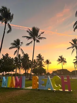 a sign that says beach with palm trees in the background at Miami Beach Rooms B&B in Miami Beach