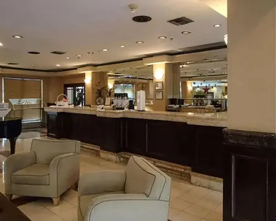 a hotel lobby with two chairs and a bar at Rodeway Inn South Miami - Coral Gables in Miami