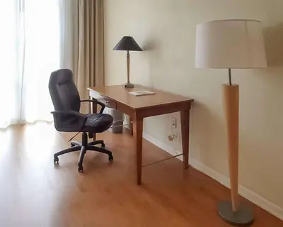 a desk with a chair and a lamp in a room at Rodeway Inn South Miami - Coral Gables in Miami