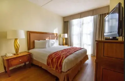 a hotel room with a bed and a television at Rodeway Inn South Miami - Coral Gables in Miami