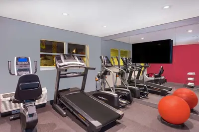 a gym with several exercise bikes and a flat screen tv at Ramada by Wyndham Miami Springs/Miami International Airport in Miami