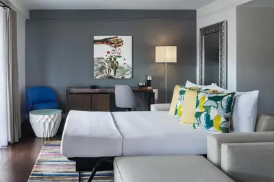 a bedroom with a bed and a couch and a desk at Hotel Colonnade Coral Gables, Autograph Collection in Miami