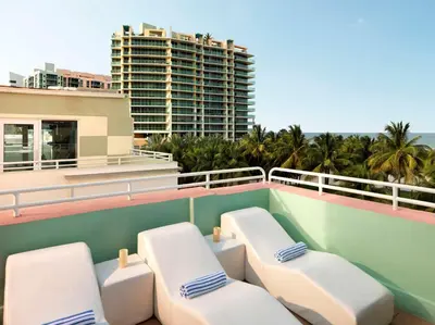 a balcony with white lounge chairs and a building at Hilton Vacation Club Crescent on South Beach Miami in Miami Beach