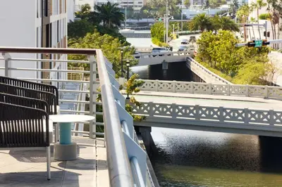 a bridge over a river with a table on a balcony at Kimpton - Hotel Palomar South Beach by IHG in Miami Beach