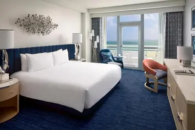 a hotel room with a white bed and a large window at Fontainebleau Miami Beach in Miami Beach