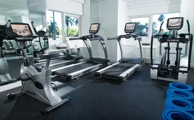 a gym with several tread machines in a room at YVE Hotel Miami in Miami