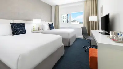 a hotel room with two beds and a television at YVE Hotel Miami in Miami