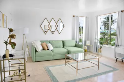 a living room with a green couch and a table at Beach Park Hotel in Miami Beach