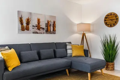 a living room with a blue couch and yellow pillows at Alani Bay Premium Condos in Fort Lauderdale