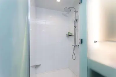 a bathroom with a shower with a glass door at Wyndham Garden Miami International Airport in Miami