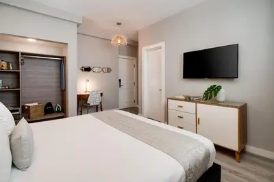 a bedroom with a white bed and a flat screen tv at Catalina Hotel & Beach Club in Miami Beach
