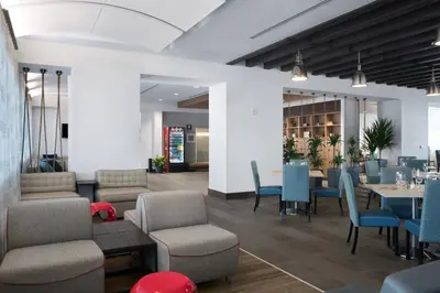 a dining room with blue chairs and tables at Four Points by Sheraton Fort Lauderdale Airport/Cruise Port in Fort Lauderdale