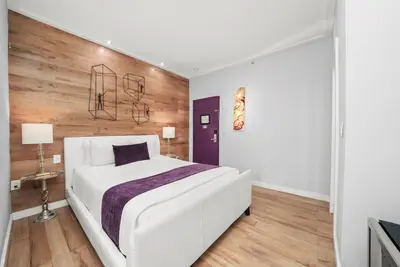 a bedroom with a white bed and a wooden wall at Shelley Hotel in Miami Beach