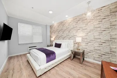 a bedroom with a white bed and a brick wall at Shelley Hotel in Miami Beach