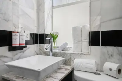 a white bathroom with a sink and a mirror at Shelley Hotel in Miami Beach