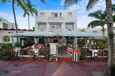 a restaurant with tables and umbrellas in front of a building at Hotel Chelsea in Miami Beach