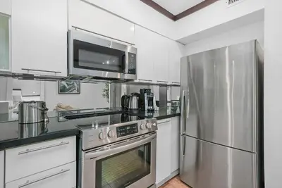 a kitchen with a stainless steel refrigerator and a microwave at Metropole Suites South Beach in Miami Beach