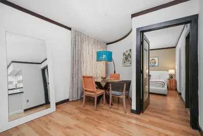 a dining room with a table and a bedroom at Metropole Suites South Beach in Miami Beach