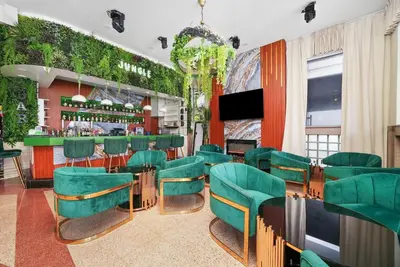 a restaurant with green chairs and a bar at Chesterfield Hotel & Suites in Miami Beach