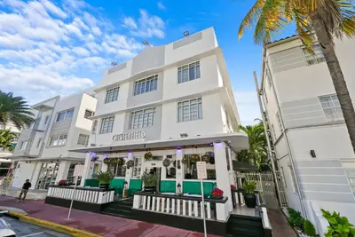 a white building with a palm tree at Chesterfield Hotel & Suites in Miami Beach