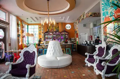 a restaurant with chairs and a table and a bar at Whitelaw Hotel in Miami Beach