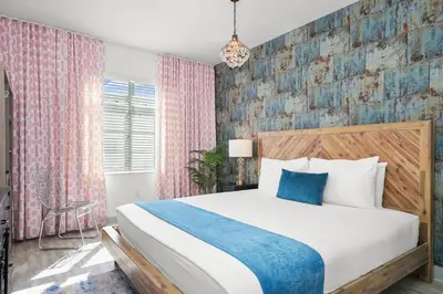 a bedroom with a bed and a pink and blue wall at Whitelaw Hotel in Miami Beach
