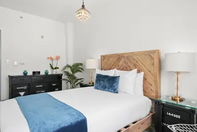 a bedroom with a large white bed with a wooden headboard at Whitelaw Hotel in Miami Beach