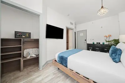 a bedroom with a bed and a tv on a wall at Whitelaw Hotel in Miami Beach