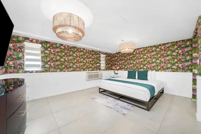 a bedroom with a bed and floral wallpaper at Whitelaw Hotel in Miami Beach