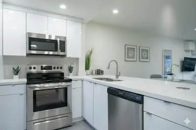 a white kitchen with a stove and a microwave at Designer River View Apartments in Fort Lauderdale