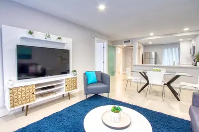 a living room with a large television and a table at Designer River View Apartments in Fort Lauderdale