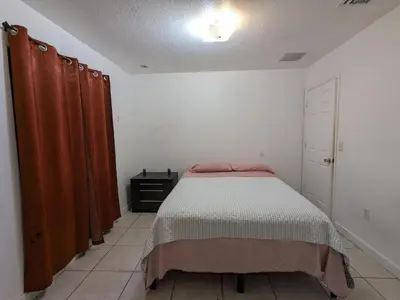 a bedroom with a bed and curtains in it at MiLuSol in Miami