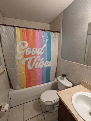 a bathroom with a cocacola shower curtain and a toilet at MiLuSol in Miami