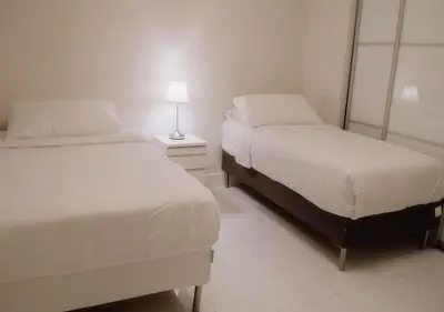 a bedroom with two beds and a lamp on a table at Cozy and Luminous Apartment - 00388 in Miami Beach