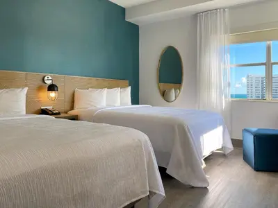 a hotel room with two beds and a window at Marseilles Beachfront Hotel in Miami Beach