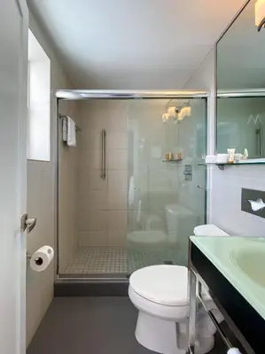 a bathroom with a shower and a toilet and a sink at Marseilles Beachfront Hotel in Miami Beach