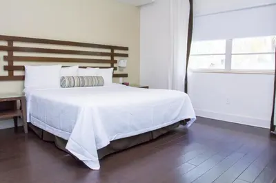 a bedroom with a large white bed and a window at Dorchester Hotel & Suites in Miami Beach