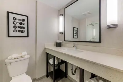 a bathroom with a sink and a toilet and a mirror at Comfort Inn & Suites Miami International Airport in Miami